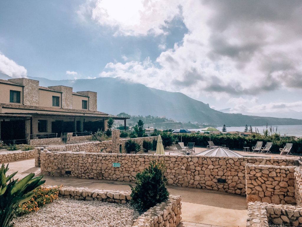 Big villa with stone walls at resort located in mountainous terrain in bright cloudy day